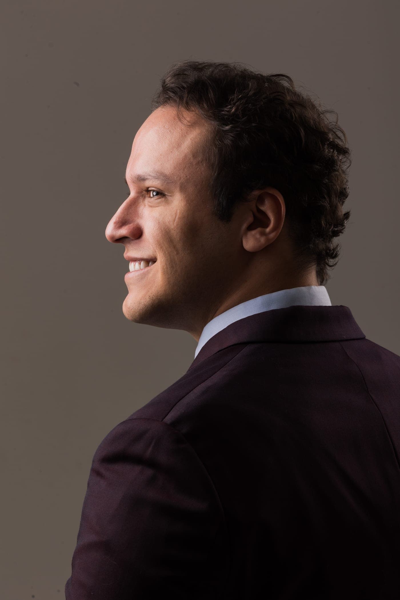 Dr. José Victor sorrindo, de perfil, em traje social