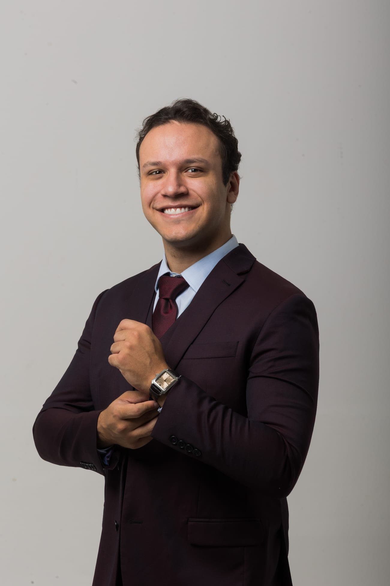 Dr. José Victor em traje social, sorrindo, ajustando o punho da camisa